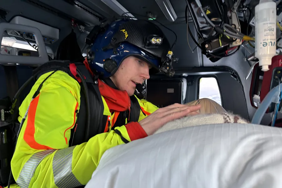 En lege har omsorg for pasient i helikopter