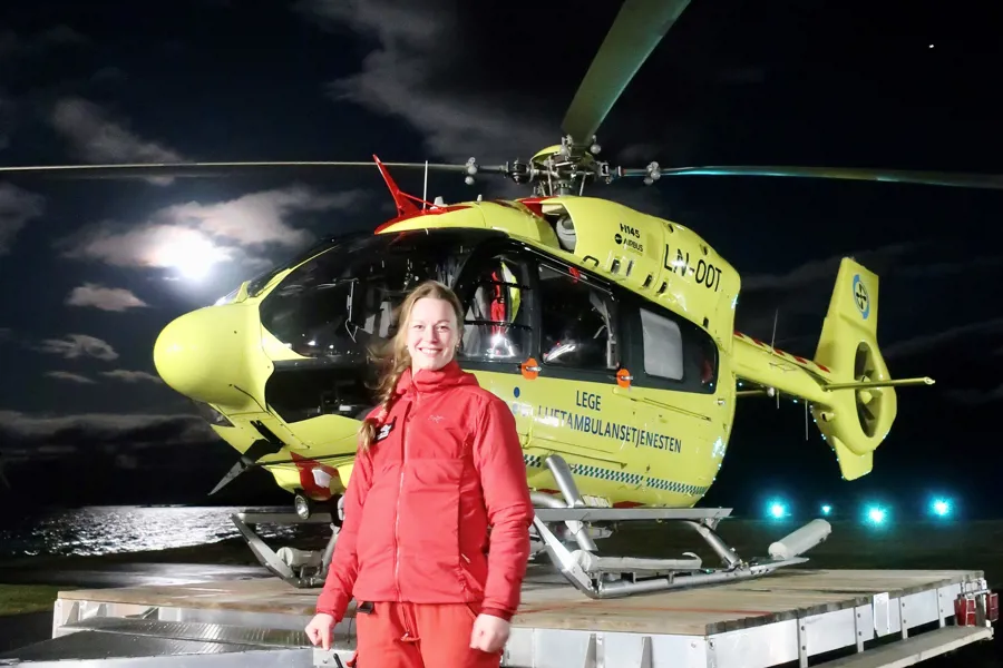 En person som står ved siden av et gult helikopter om natten