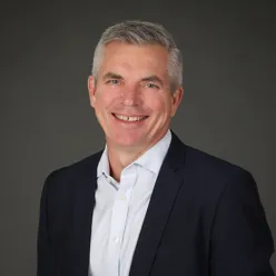 En mann i dress som smiler